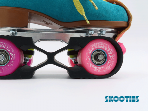 A black Skootie is looped over the inside wheels of a turquoise roller skate boot. The focus is on the pink wheel towards the pink toestop, showing the way the loop of a Skootie hugs the wheel.